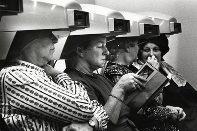 107697 Afbeelding van enkele modellen onder de droogkappen in de Kappersvakschool (Nachtegaalstraat 29c) te Utrecht.